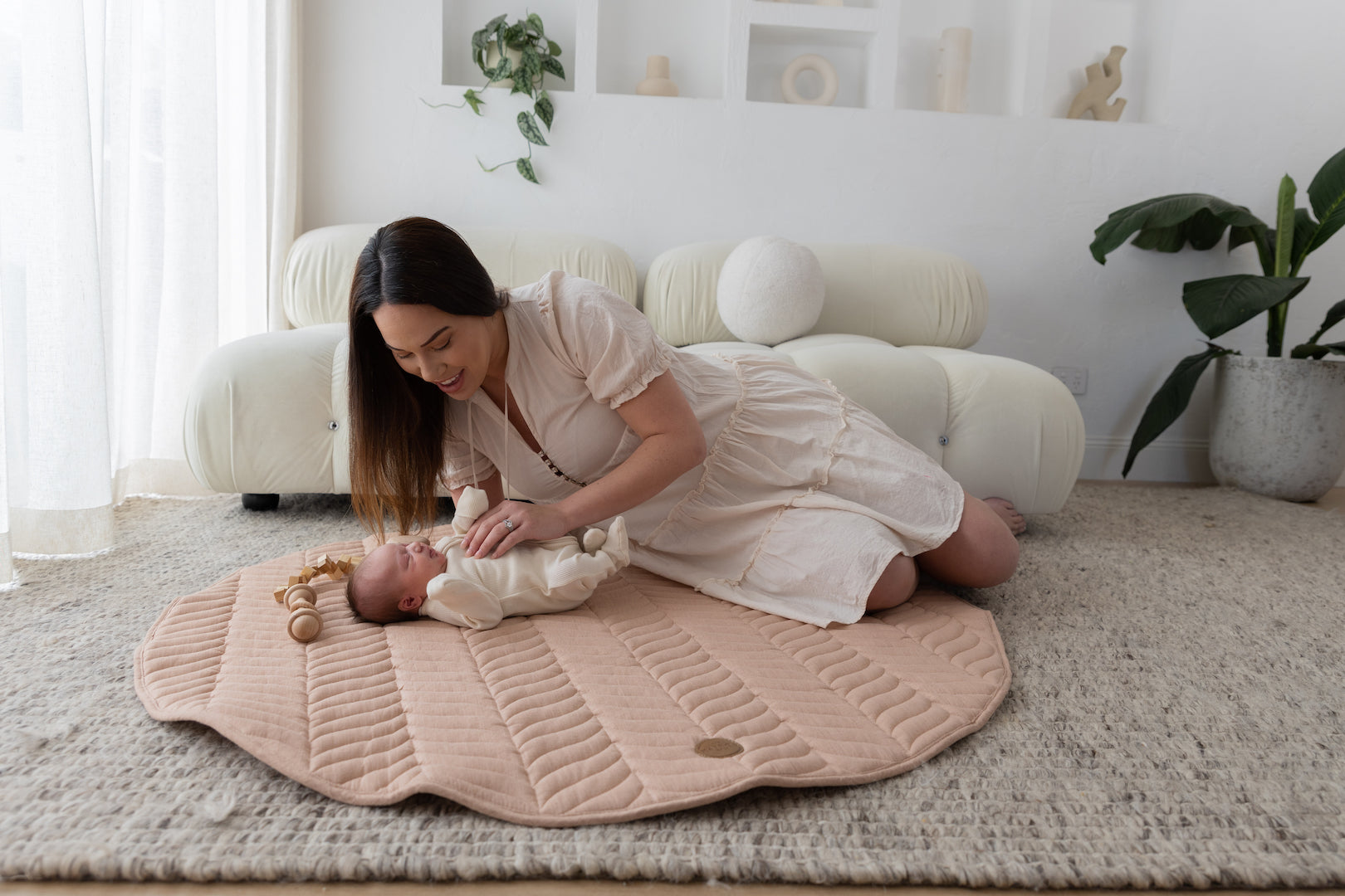 mother bonding with newborn on The Kairos Child Pampas play mat during tummy time