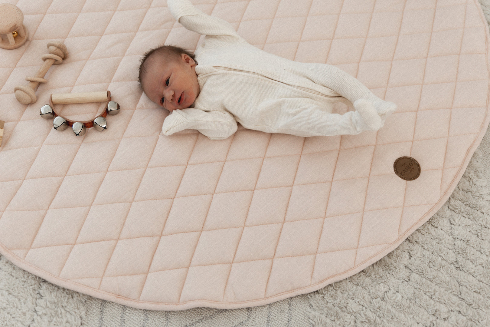 Baby stretching out on The Kairos Child's Positano play mat